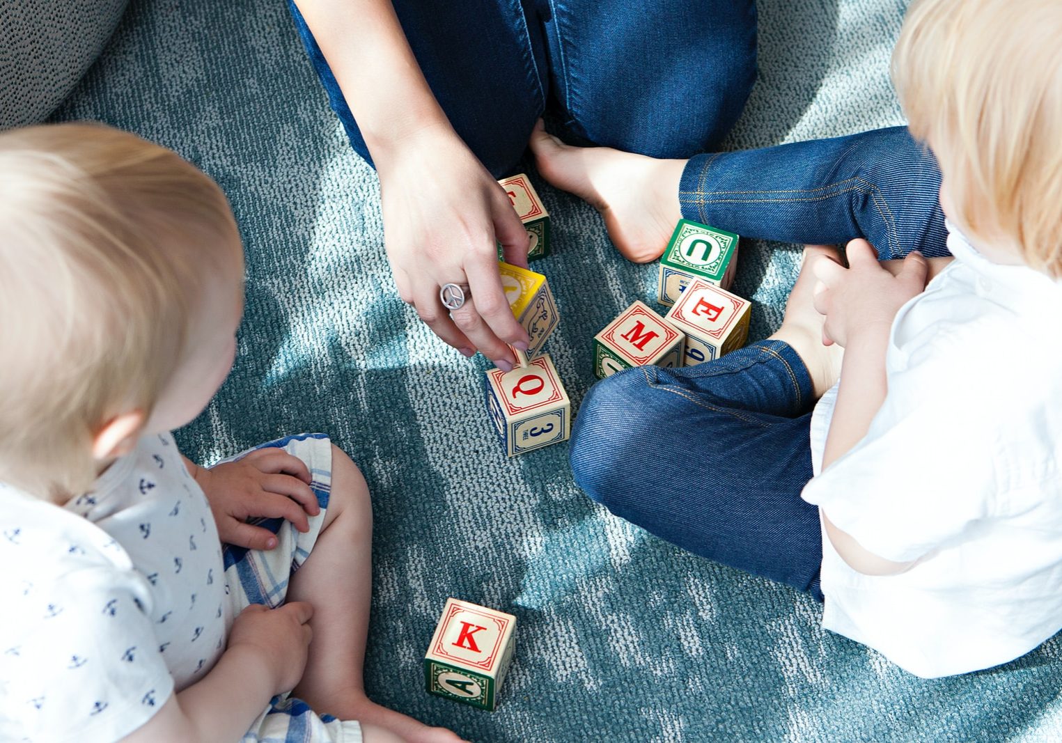 two toddler playing letter cubes